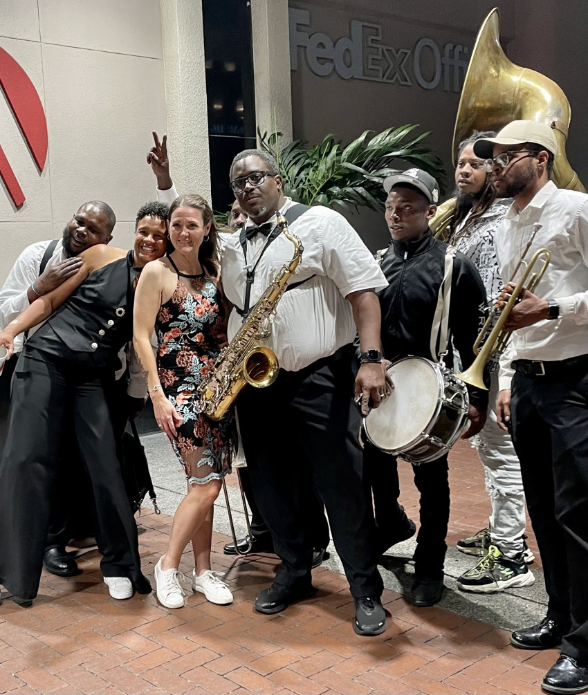 Truth Be Told Brass Band posing with guests after a performance
