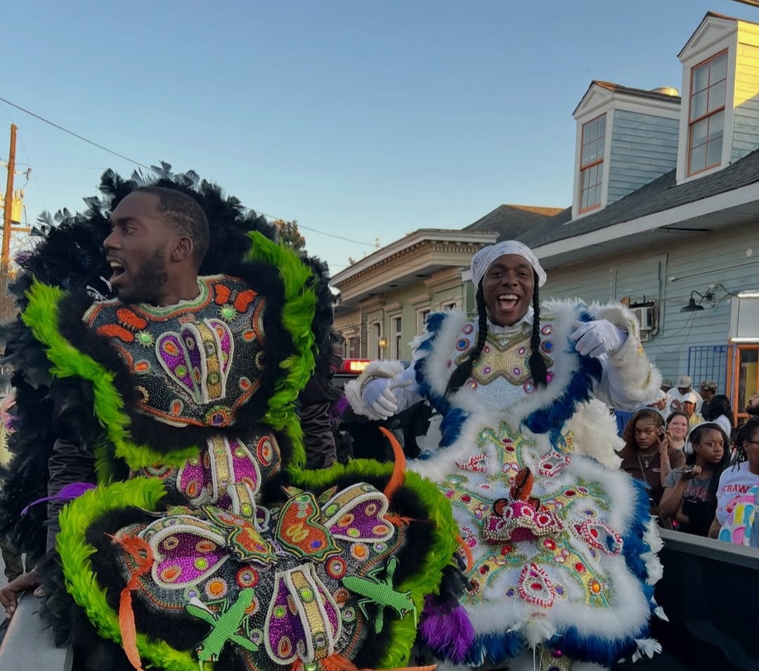 Mardi Gras Indian performers outdoors at golden hour