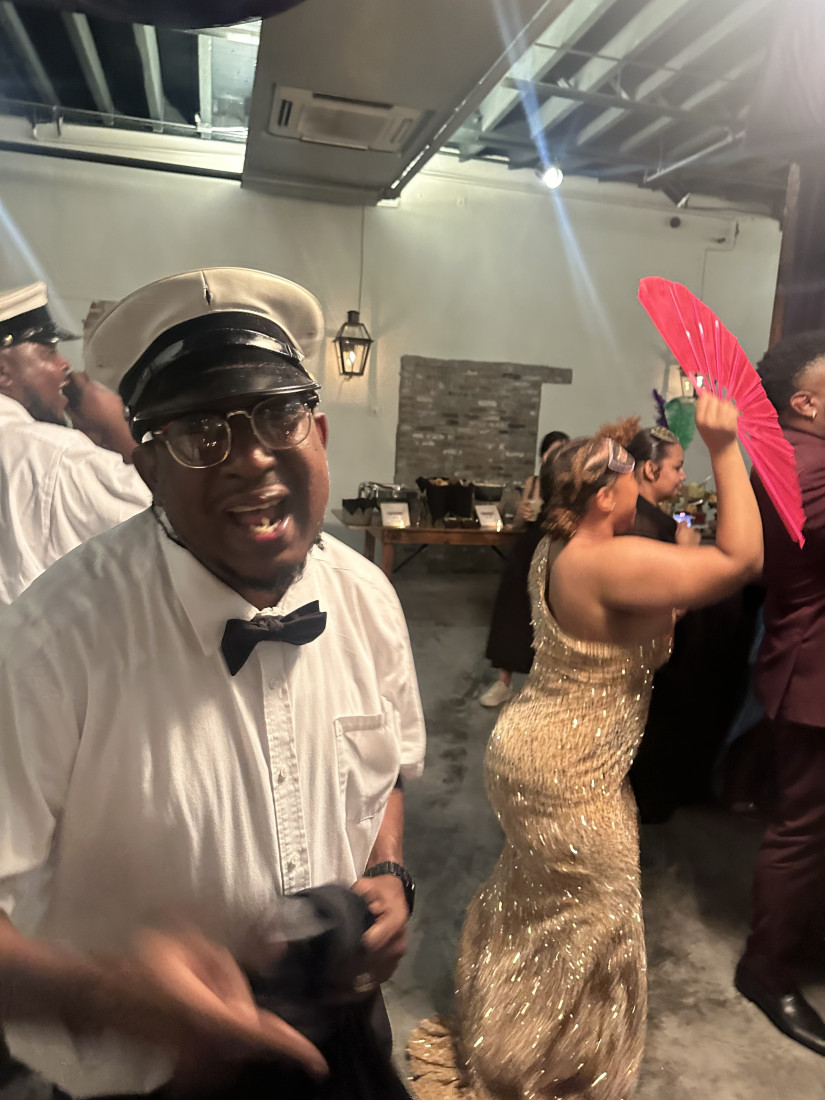 Band member in formal attire leading a party moment
